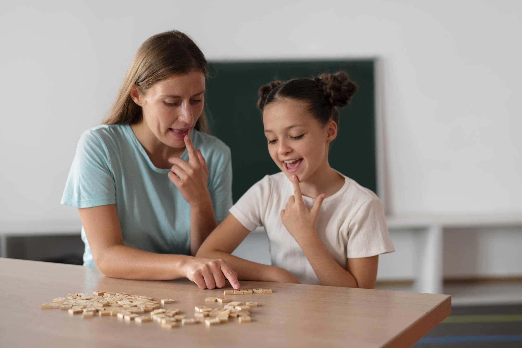 A speech language pathologist working through a sound with a patient across a table.